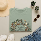 The World Is Our Classroom homeschool mom graphic t-shirt with an adventurous homeschool graphic with nature, books, and outdoor learning energy